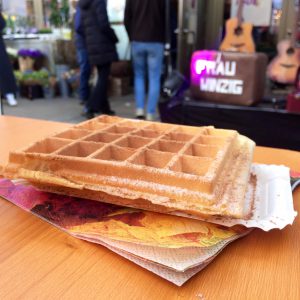 Waffle on a table at Markthalle, Cologne, with a stage behind