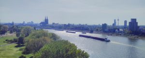 Skyline of Cologne with large cargo ships travelling up the Rhine