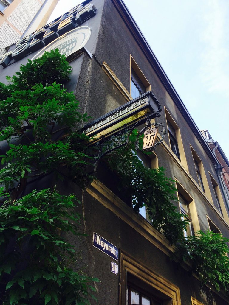 Close-up of the Haus Töller sign above a street sign at Weyerstrasse, Cologne