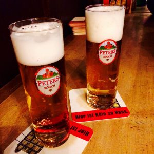 Close-up of two full Peters Kölsch Glasses on Peters beer mats