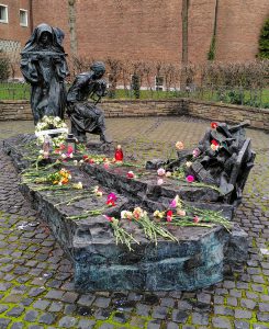 The Edith Stein Monument in Cologne covered in flowers