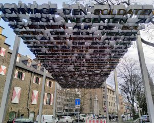 Looking up through the metal letters of the deserter momument in Cologne