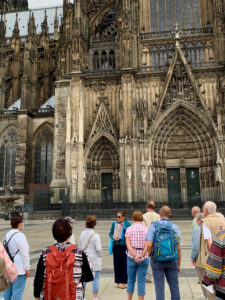 Walking tour group learning about the history of the Cologne Cathedral