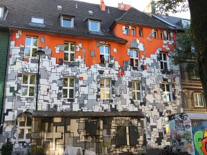 Apartment building entirely painted with a geometric pattern in grey and orange