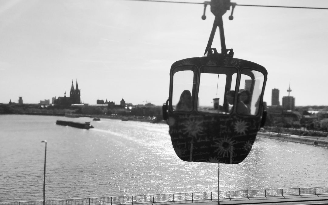 Monochrome cable car above the river Rhine with Cologne Cathedral in the background