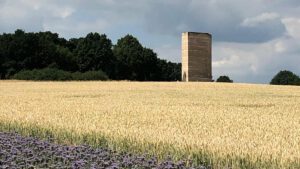 Zumthor's Field Chapel near Cologne viewed from a distance with dark clouds above