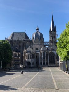 The towers of Aachen Cathedral with an empty marketplace in the foreground