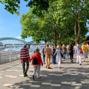 Tour group walks along the riverbank in Cologne